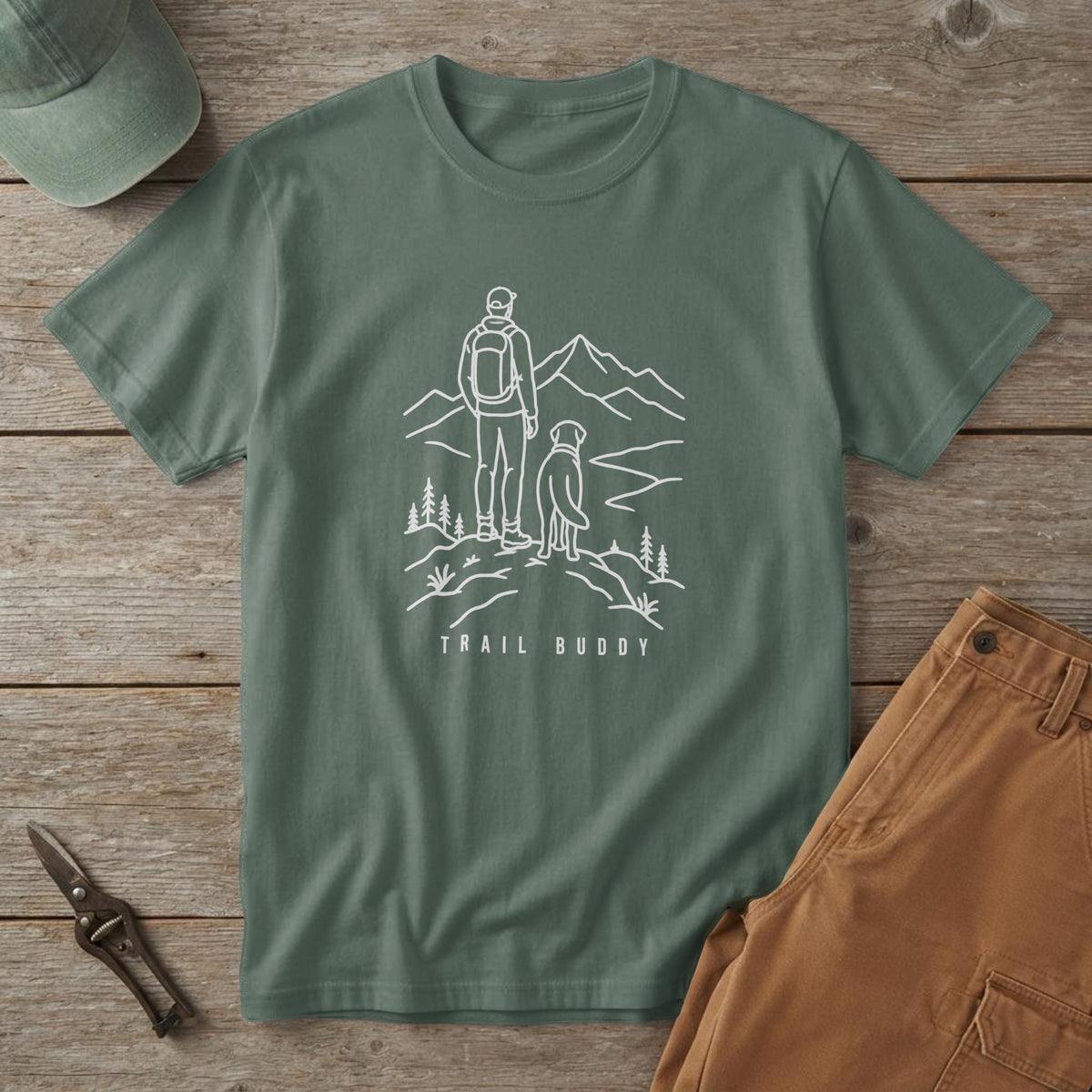 Blue Spruce t-shirt with a white line drawing of a man and dog on a mountain ridge and the words "Trail Buddy"