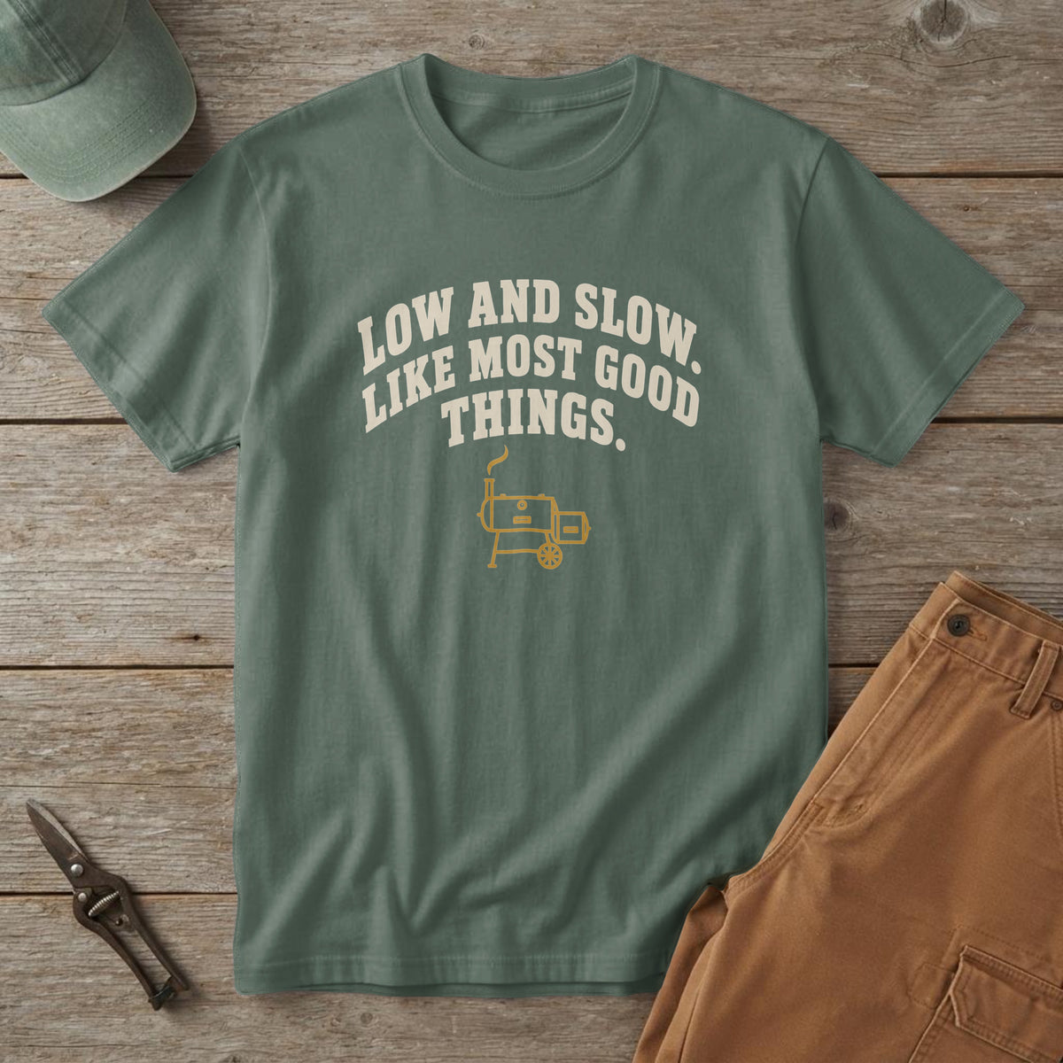 Blue Spruce t-shirt with arched cream type reading "Low and Slow. Like Most Good Things." over a small smoker