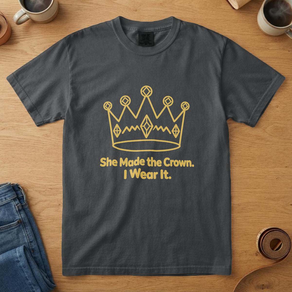 Black t-shirt with a yellow drawing of a paper crown and the words "She Made the Crown. I Wear It."