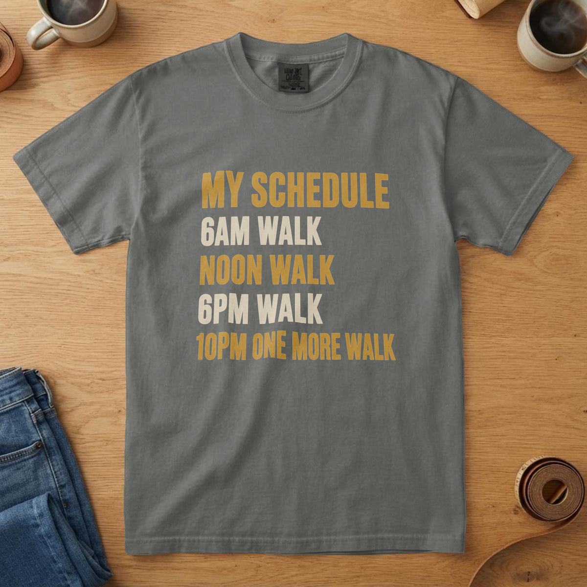 Pepper t-shirt with bone and mustard bold type listing "MY SCHEDULE / 6AM WALK / NOON WALK / 6PM WALK / 10PM ONE MORE WALK"