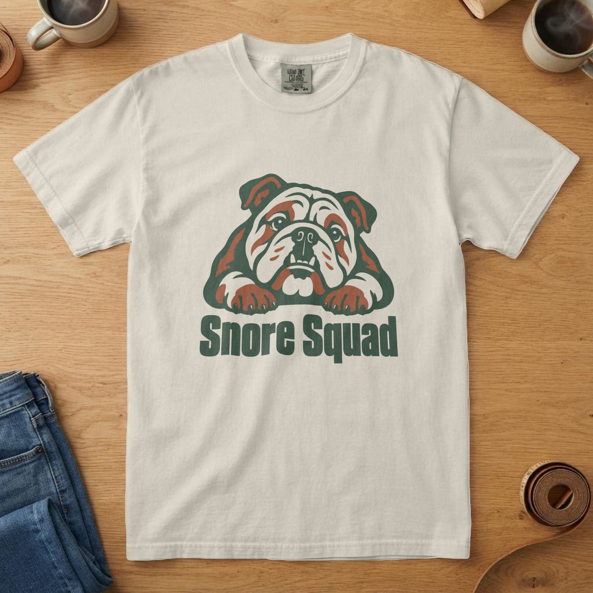 Ivory t-shirt with a forest and rust English Bulldog illustration and the words "Snore Squad"