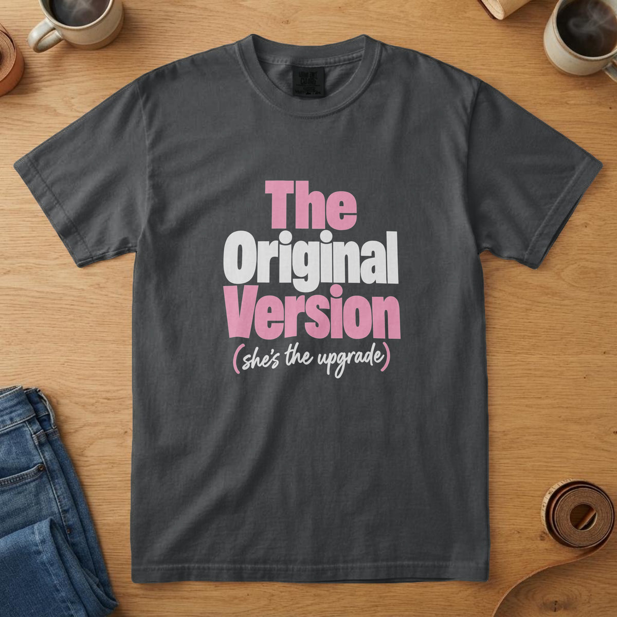 Black t-shirt with bold pink and white type with a script line and the words "The Original Version (she's the upgrade)"