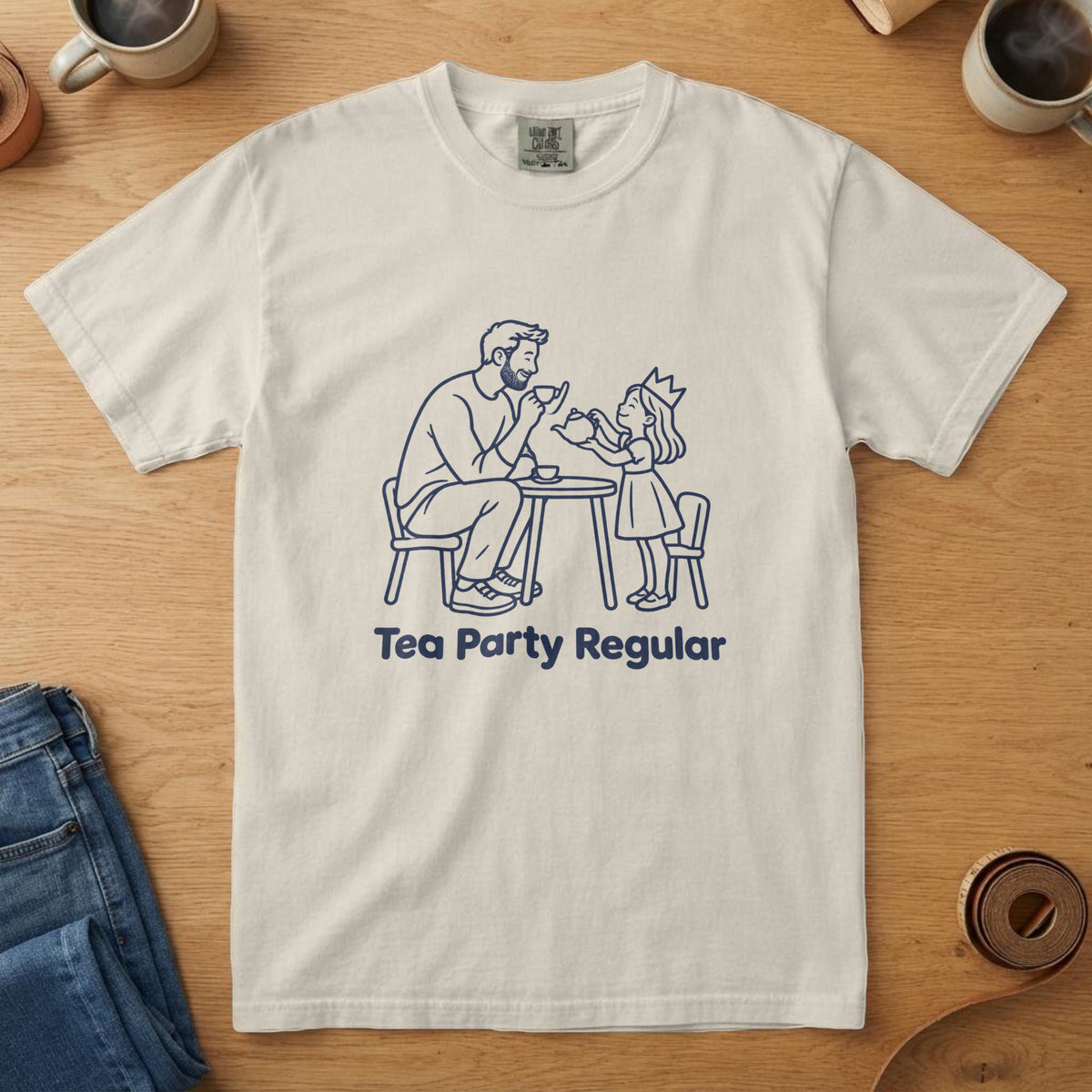 Ivory t-shirt with a navy line drawing of a dad and daughter at a tea party and the words "Tea Party Regular"