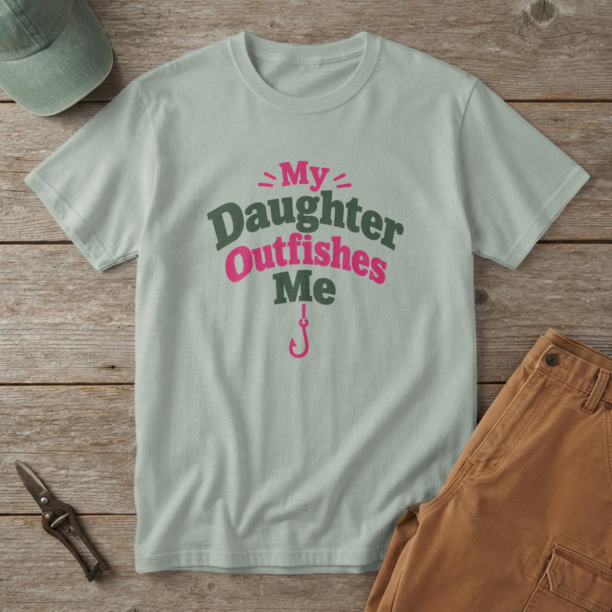 Bay t-shirt with green and pink lettering above a small fishing hook and the words "My Daughter Outfishes Me"